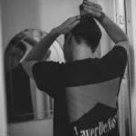Homme se coiffant devant un miroir
