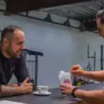 Deux hommes préparent un shaker de whey à la salle de sport
