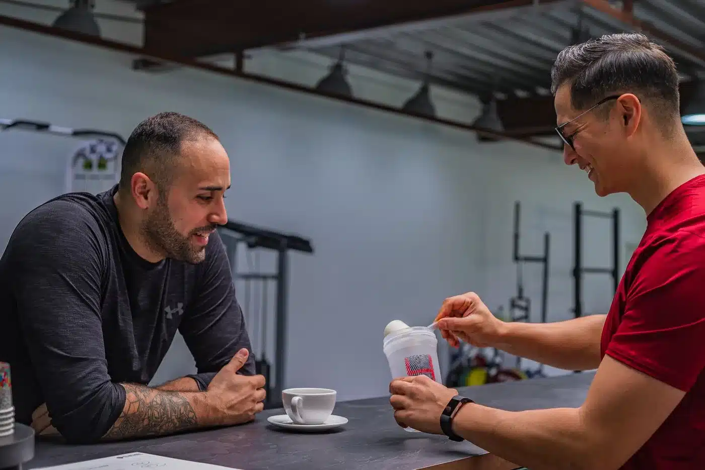 Deux hommes préparent un shaker de whey à la salle de sport