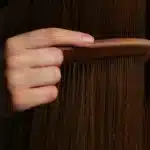 Un peigne passé dans de longs cheveux, la question de la chute de cheveux