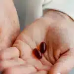 Deux mains tenant des compléments différents : comparer une formule de pharmacie et une autre gamme