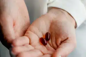 Deux mains tenant des compléments différents : comparer une formule de pharmacie et une autre gamme