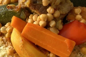 Gros plan sur un couscous aux légumes, pois chiches, carottes et courgette, article sur l'alimentation marocaine du coureur