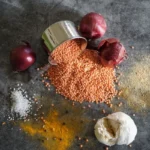 Lentilles rouges crues avec oignon, ail et épices vus de dessus, aliments riches en fer de la cuisine marocaine, guide anémie et carence en fer au Maroc