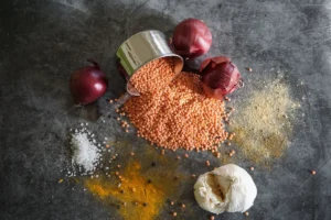 Lentilles rouges crues avec oignon, ail et épices vus de dessus, aliments riches en fer de la cuisine marocaine, guide anémie et carence en fer au Maroc
