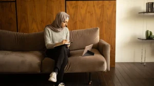 مرا جالسة فالصالون كتكتب ملاحظات فكناش، صورة توضيحية
