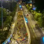 Vue aérienne de coureurs sur une avenue éclairée la nuit, guide pour courir pendant le Ramadan au Maroc