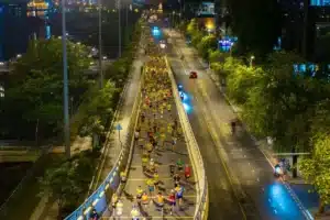 Vue aérienne de coureurs sur une avenue éclairée la nuit, guide pour courir pendant le Ramadan au Maroc