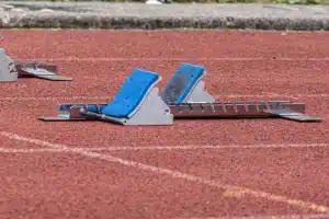 Starting-blocks posés sur une piste d'athlétisme rouge, article sur la créatine pour les coureurs au Maroc