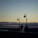 Silhouette d'un coureur sur une corniche au coucher du soleil, guide pour commencer le running au Maroc sans se blesser