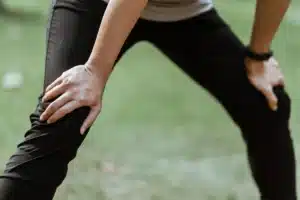 Coureur essoufflé penché en avant, mains posées sur les genoux dans un parc, article sur la carence en fer et le running au Maroc