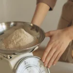 صورة توضيحية: شخص يوزن حصة من المسحوق بميزان المطبخ