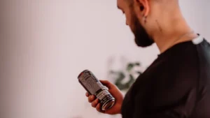 شخص كيقرا المعلومات المكتوبة على علبة مكمل غذائي، صورة توضيحية