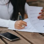 شي وحدة كتكتب تتبع الأعراض فكناش على طبلة ديال الخشب، صورة توضيحية