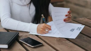 شي وحدة كتكتب تتبع الأعراض فكناش على طبلة ديال الخشب، صورة توضيحية