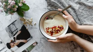 Des mains tiennent un bol garni sur une table, photographie d’illustration.