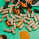 Gélules, capsules souples et poudre de compléments alimentaires avec une cuillère sur fond vert, guide des prix des compléments au Maroc
