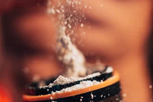 Poudre de pre-workout versée dans un shaker ouvert, article sur le moment où prendre son pre-workout au Maroc