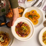 Photographie d'illustration : table marocaine avec tajine, agrumes et soupe, repas d'hiver