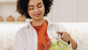 Personne versant une boisson dans un verre sur un plan de cuisine, photographie d'illustration