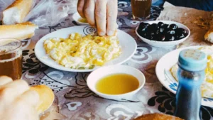 Photographie d’illustration : table de petit-déjeuner marocain avec pain, œufs brouillés, olives et thé