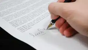 Main qui signe une lettre au stylo plume
